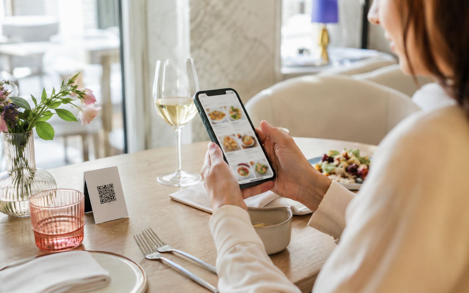 Un client consulte une carte digitale à table.